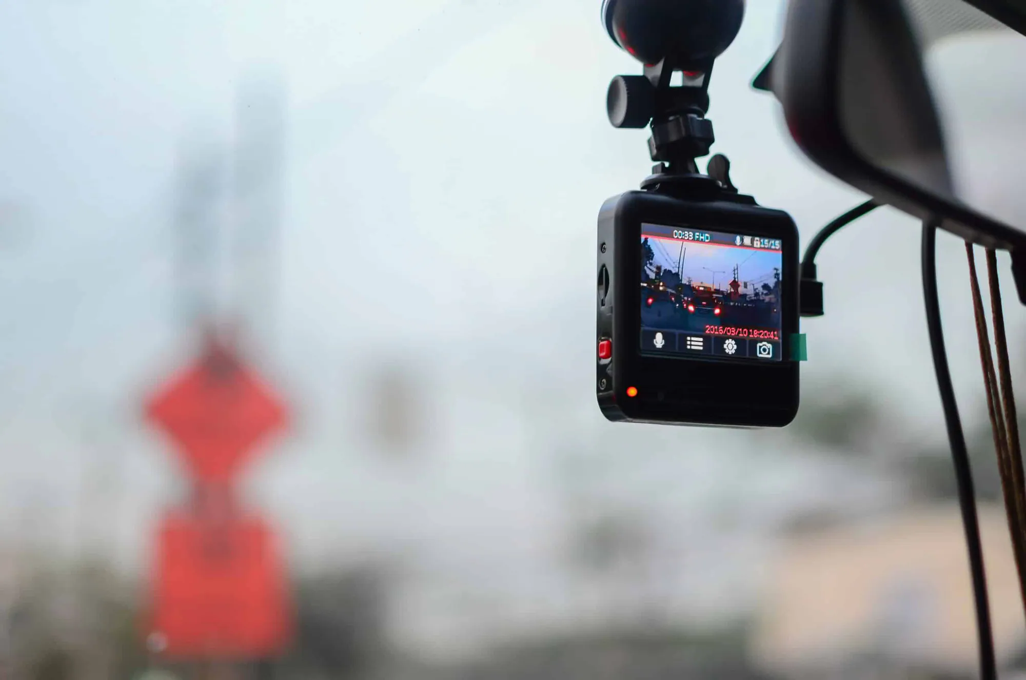 A dashboard camera mounted on a windshield, recording the road ahead