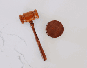 Wooden gavel resting on a white granite desk.