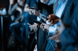Group of pedestrians using their phones at a subway stop.