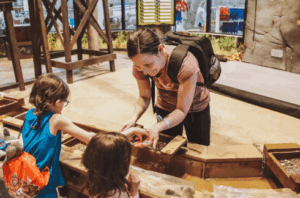 Woman participating in a family fun activity with her two children.