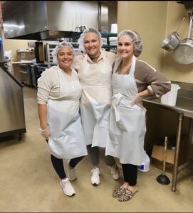 Three Scott Pryor Law Group employees volunteering at Atlanta Mission Organization kitchen.